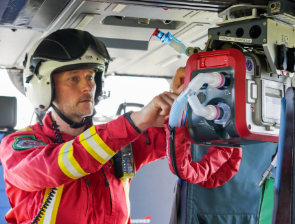Critical Care Consultant inside the helicopter using the ventilator on board.