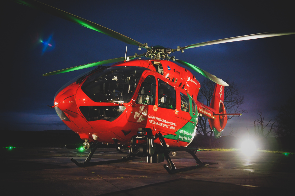 The WAA helicopter on the helipad in the night with dark skies.