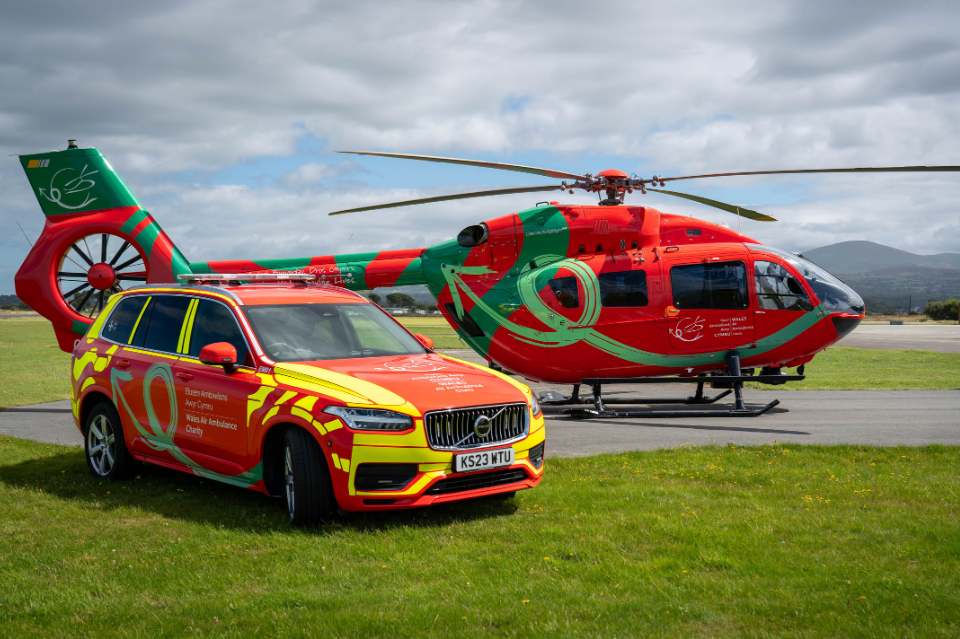 Rapid response vehicle and helicopter on airfield with mountains in background
