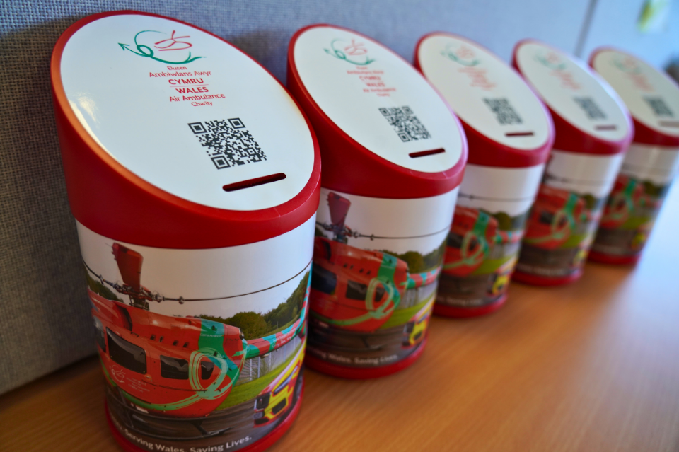 Row of collection tins with Wales Air Ambulance branding