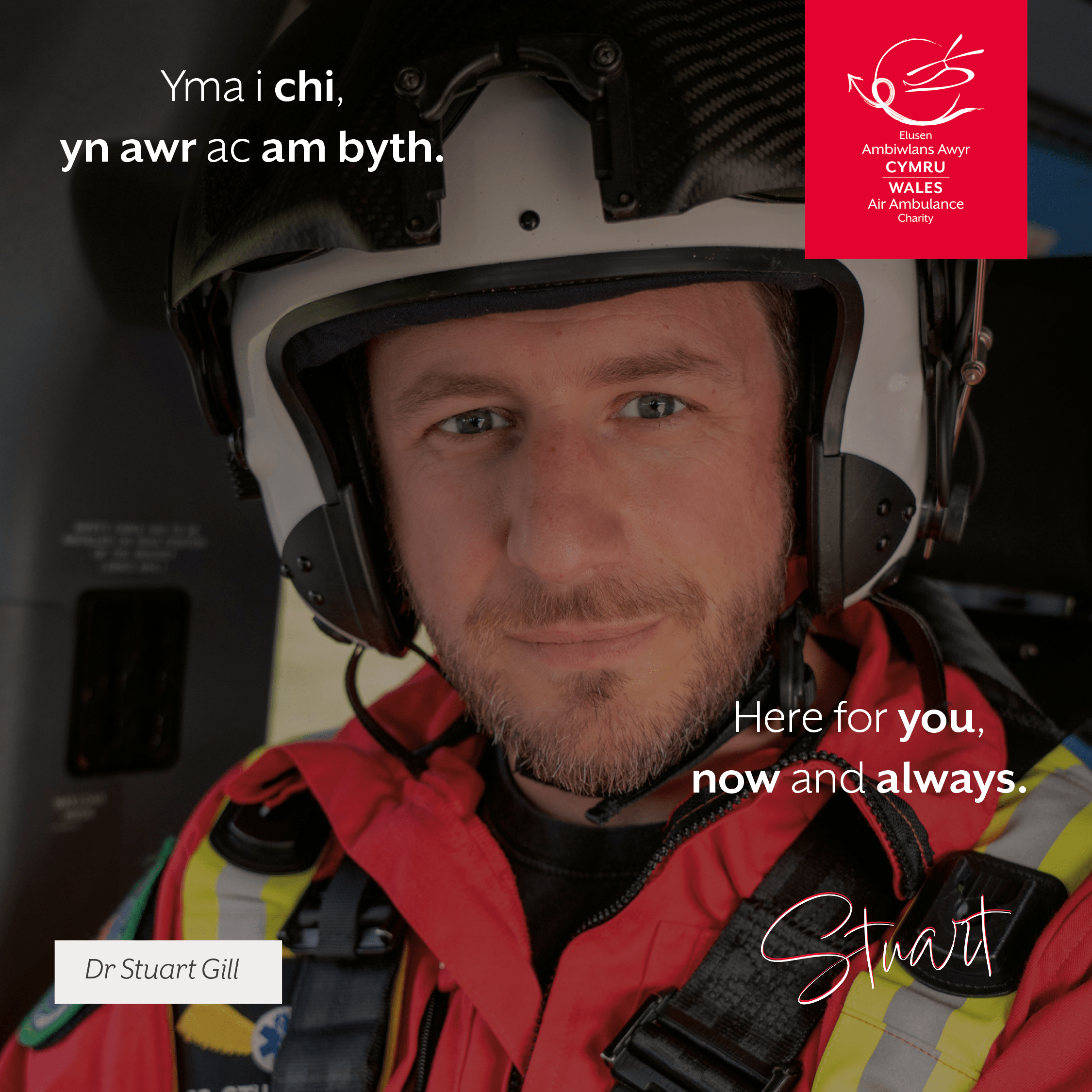 Close up picture of Stuart, a consultant, saty in the helicopter directly looking to camera with his helmet on. With the words Here for you, now and always.