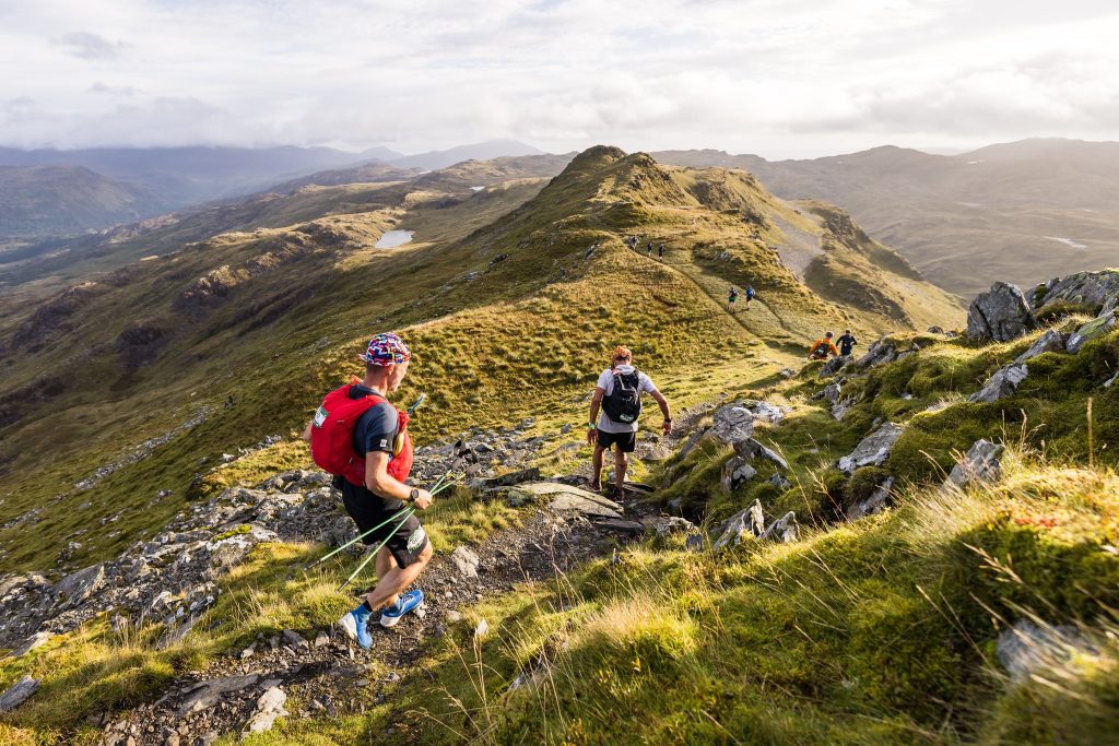 Two men running over the mountains in Wales